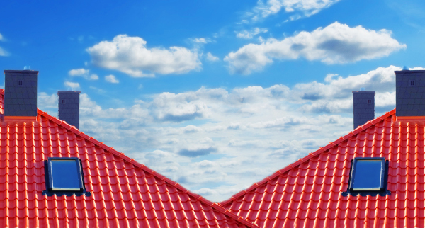 newly renovated roof with red finish with two chimneys