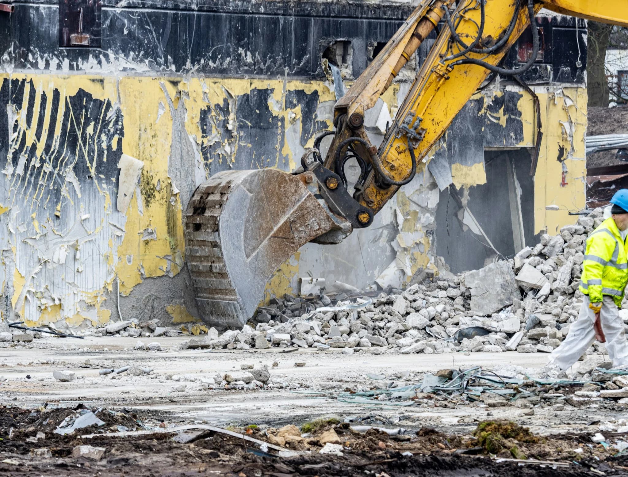 Excavator performing professional demolition services, breaking down a damaged building as part of Vreeland Roofing's site preparation solutions in Florida.