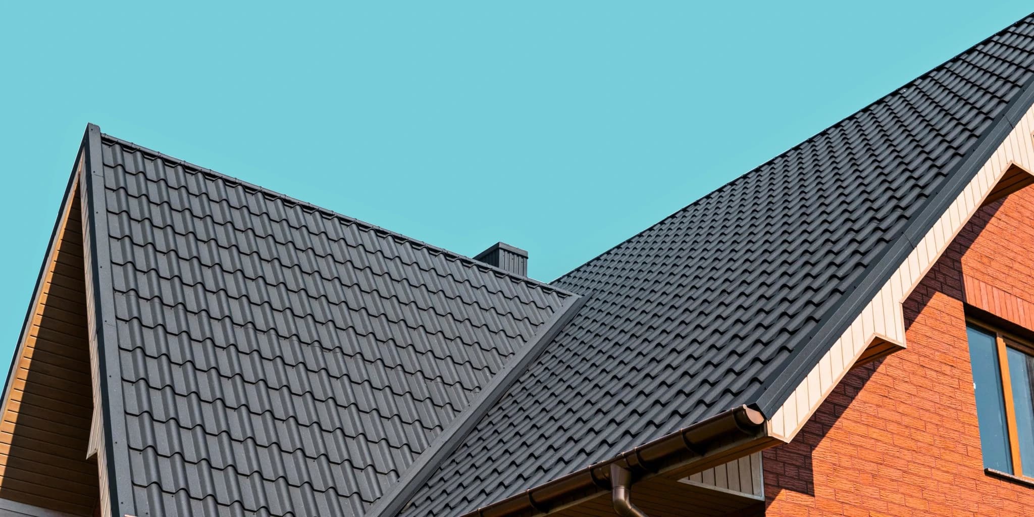 Close-up of a modern black metal tile roof installed by Vreeland Roofing. This durable and weather-resistant roofing solution enhances the home's aesthetic appeal while providing long-lasting protection.